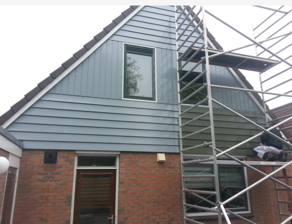 PNA Schilders – Buitenschilder aan het werk in Winschoten Schilder van PNA Schilders bezig met buitenschilderwerk aan woning in Winschoten